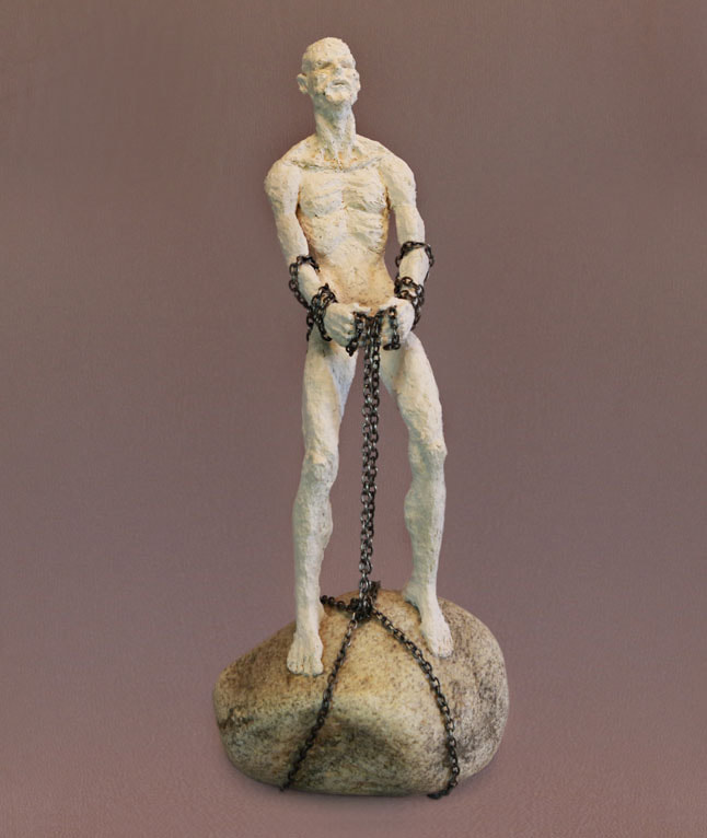 sculpture of man on a boulder pulling on a chain